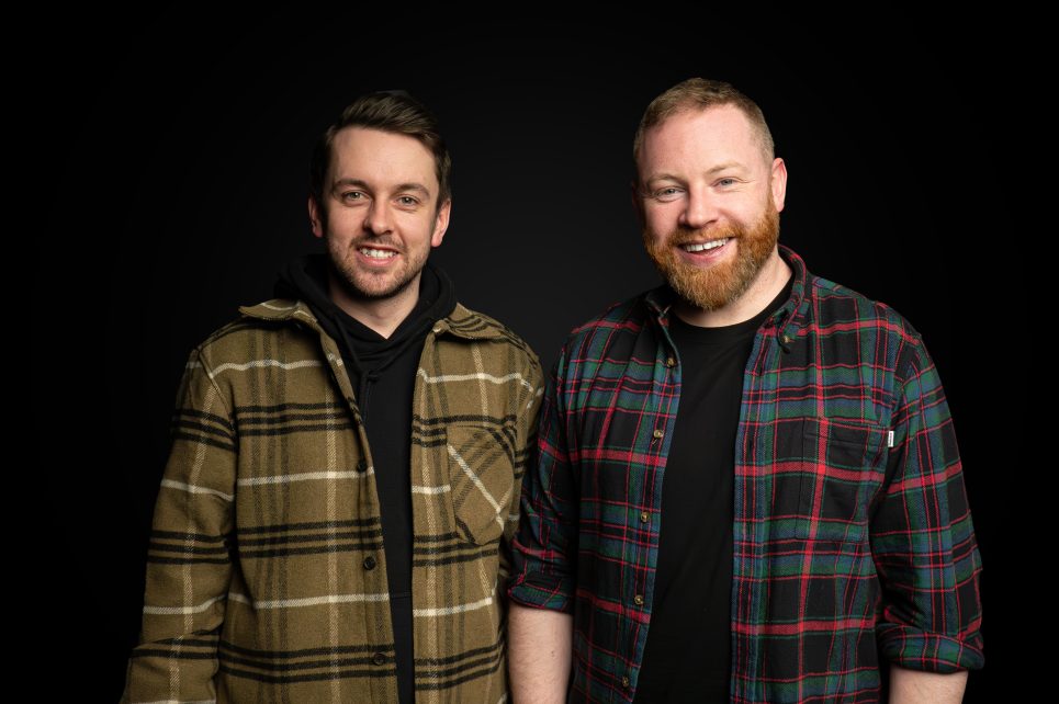 Kendy and Raybo are smiling and wearing plaid shirts in front of a black background Kendy and Raybo are smiling and wearing plaid shirts in front of a black background