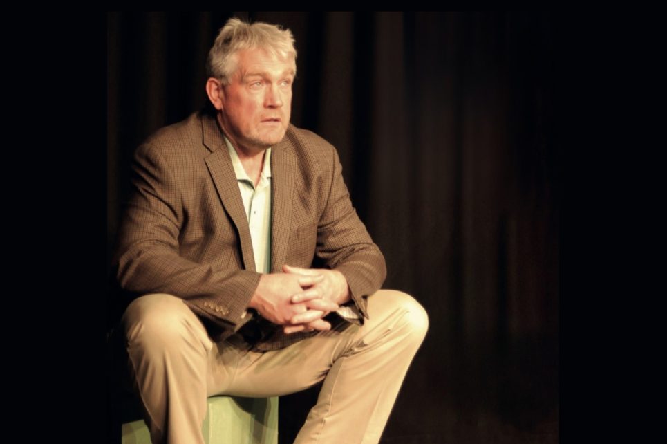 Seamus O'Rourke sits in a chair with a black background behind him
