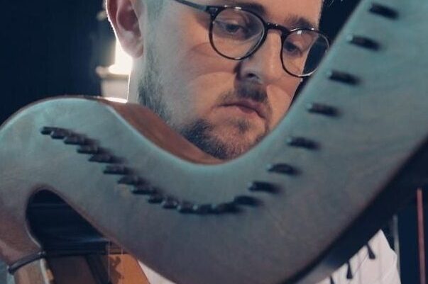 Man in glasses playing the harp