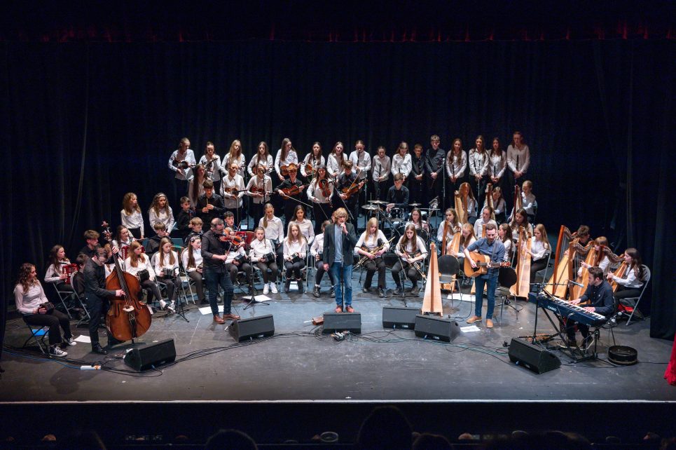 The Ceol na nÓg Trad Orchestra on stage with Seán Keane, Michael Doherty, and Michael Rooney
