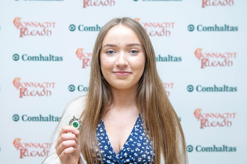 A photograph of Ailise Maxwell against a Connacht Fleadh backdrop A photograph of Ailise Maxwell against a Connacht Fleadh backdrop