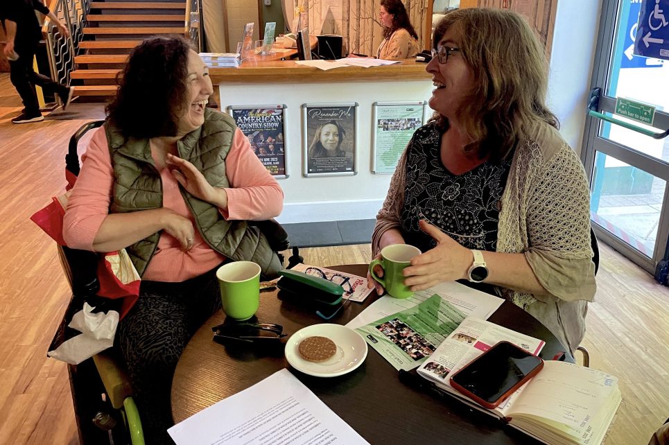 An image of theatre patrons laughing over a cup of tea An image of theatre patrons laughing over a cup of tea