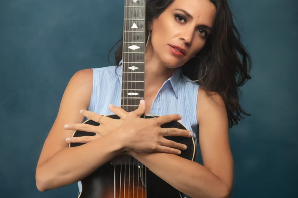 A portrait photograph of Eleonora Strino with a guitar