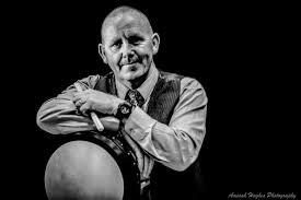 A black and white photograph of Junior Davey with a bodhran A black and white photograph of Junior Davey with a bodhran