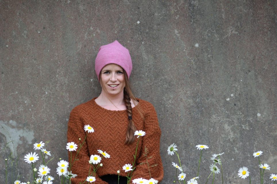 A photograph of Jenny Hallahan in a pink hat